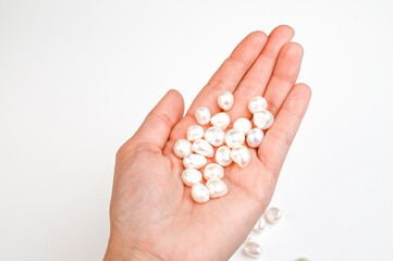 Close-Up of woman hand with pearl bead in female hand. Hand with string of baroque pearls