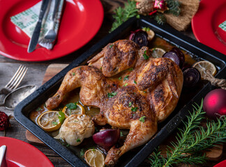 Christmas roast chicken on rustic wooden table with plates and cutlery