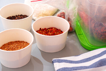 Bowls with various spices on kitchen table.