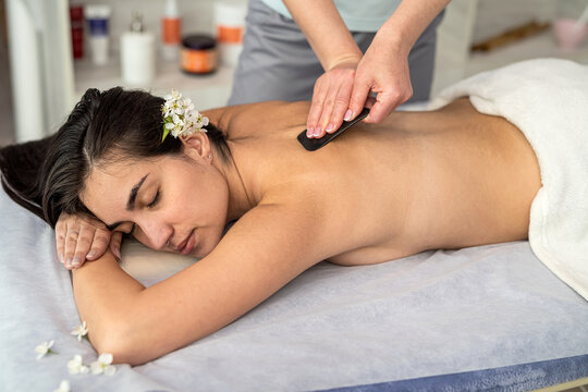 spa therapist make relax massage with a gouache scraper in salon