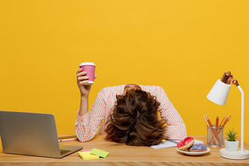 Young employee business woman wear shirt sit work at office desk with laptop hold takeaway paper cup coffee to go put head on desk isolated on plain yellow color background Achievement career concept - obrazy, fototapety, plakaty