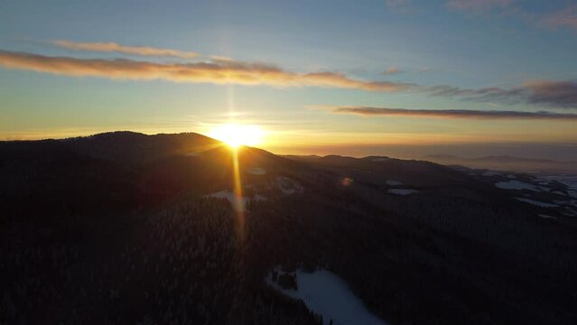 Snow capped mountains in the winter, aerial view. Aerial view of winter mountain landscape and colorful sunset sky. Gorce high mountains and magical unspoiled scenery.