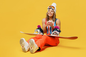 Snowboarder woman wear orange suit goggles mask hat ski costume swimsuit spend extreme weekend sit...