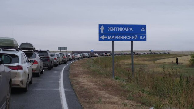 Long queue of cars standing in large traffic jam at customs border crossing between Russia and Kazakhstan after announcement of partial mobilization in Russia. Shooting in slow motion