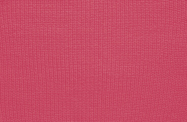Texture of smooth knitted sweater with pattern. Handmade knitting wool or cotton fabric texture. Background of Large knit pattern with knitting needle or crochet. Color Of The Year 2023 - Viva Magenta