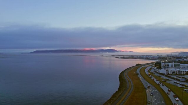 Evening Traffic Driving On Atlantic Ocean Coastal City Road With Beautiful Blue Hour Twilight Sunset In Background. Aerial Drone View.