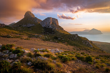 Sunset overlooking the mountain of Monte Monaco. Colorful sky. The golden hour and in the distance the Mediterranean coast and the Monte Cofano mountain. Sicily, Italy