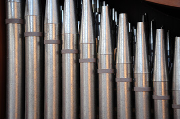 Church pipes attached to an organ indoors.