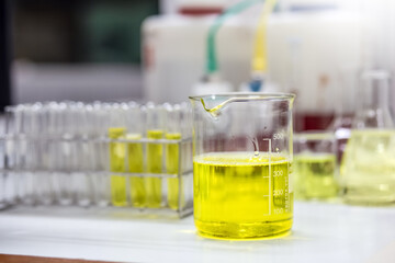 Pale yellow solution of an emulsifier a beaker for formulation test of the cosmetic product in the laboratory or industry. Research and Development cosmetics.