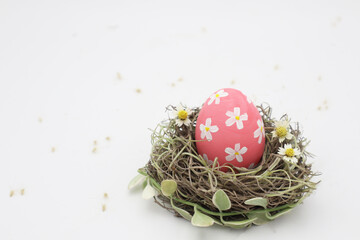 Obraz premium Pink pastel easter egg in nest 