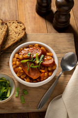 Beans with sausage and tomato sauce in bowl. Beans stew, homemade rustic english food. Rustic wooden background.