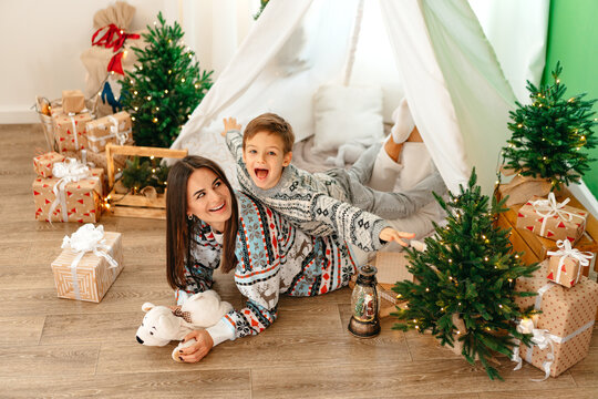 Happy mom and son enjoying Christmas together in cozy home