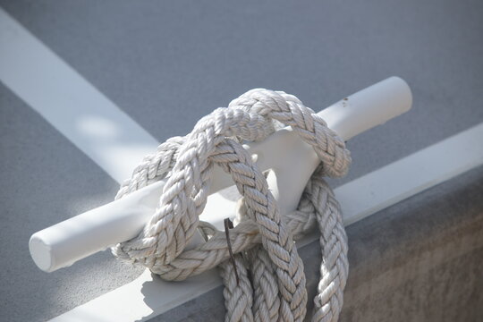 Stainless steel mooring bollard with knotted rope mounted on the deck