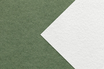Texture of dark green paper background, half two colors with white arrow, macro. Structure of craft...