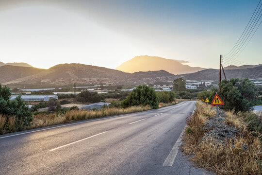 Greece, Crete, Agia Galini, Empty country road at sunset