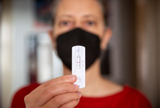 Hand's of woman showing positive Covid-19 rapid test