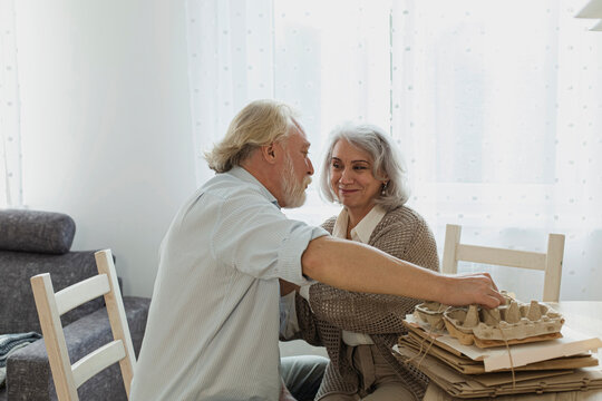 Senior couple bunching waste paper at home