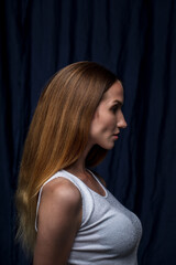 Naklejka premium portrait of a young attractive woman on a dark background