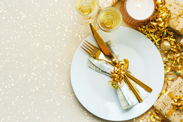 Christmas dinner concept. Top view of golden cutlery on a plate with christmas ornament and space for text