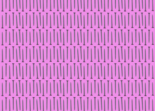 Pattern of rows of screws flat laid against pink background