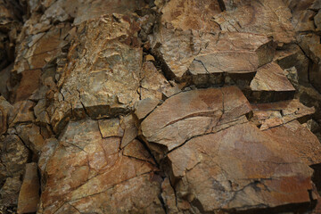 Brown orange red rock texture. Cracked mountain surface. Close-up. Stone background for design. Broken crumbled crushed. Rusty color.