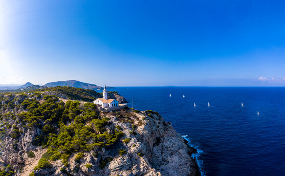Aerial view of Far de Capdepera lighthouse with steep coast under clear sky