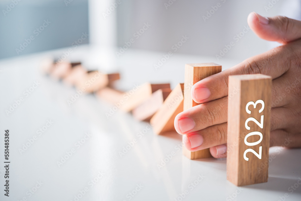 Poster man hand stop domino falling effect to the last 2023 wood block