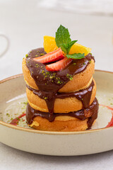 Stack of sweet pancakes with chocolate and fruits