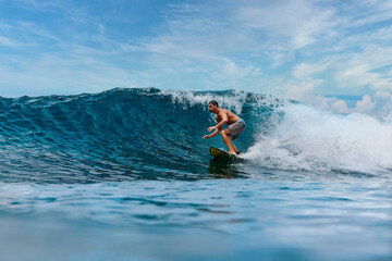 Shirtless male surfer on a wave at sunny day