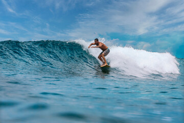 Shirtless male surfer on a wave at sunny day