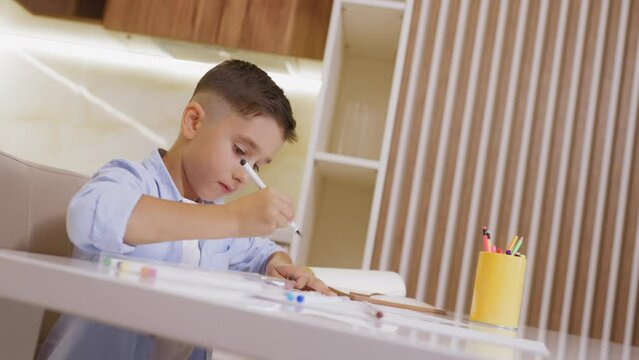 Upset boy drawing picture with black marker, domestic violence victim aggression
