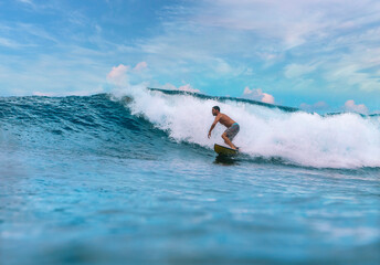 Shirtless male surfer on a wave at sunny day