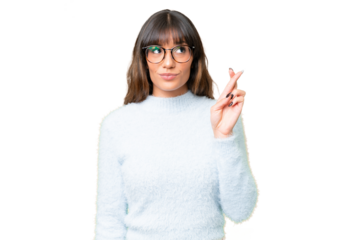 Young caucasian woman over isolated chroma key background with fingers crossing and wishing the best