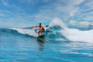 Shirtless male surfer on a wave at sunny day