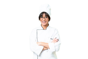 Young caucasian chef  woman over isolated chroma key background keeping the arms crossed in frontal...