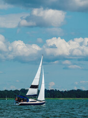one sailing yacht sailing at full sail on a lake