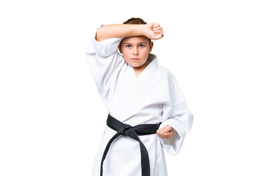 Little caucasian kid over isolated chroma key background doing karate