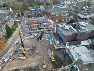 Screw pile driving machine on building site Cambridge City centre UK drone aerial..