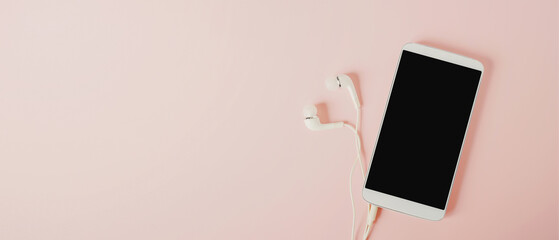 top view of white smartphone with clopping path on screen  and earphone on sweet pink background...