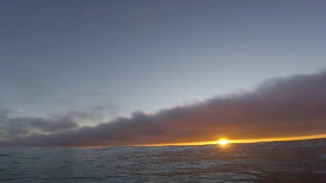 Action cam outdoor follow the bodyboard floating in Slow Motion in sunset time