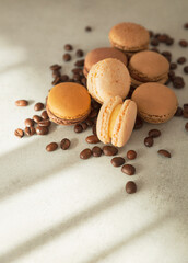 Chocolate hazelnut macaroon, macaroons close-up with coffee beans on a gray background. French...