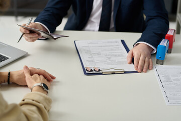 Close up of visa application form with photos and documents on table in immigration office, copy...