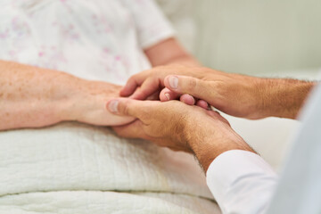 Holding hands to comfort seniors in hospice