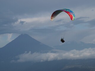 People paragliding with mountains in the background