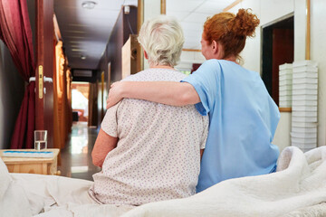 Caring nurse hugging sick old woman - obrazy, fototapety, plakaty