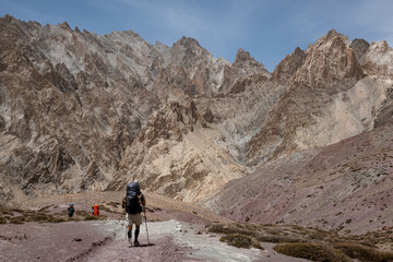 Alone trekkers walking in the mountains with backpacks. Small Himalayas 