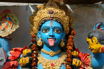 Portrait of the goddess Kali with her tongue hanging out and a severed head in her hands.