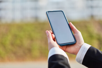 Hands of businesswoman holding smartphone as mock-up template