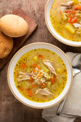 Top view of homemade rice and chicken soup in a bowl. Topmview, vertical image.