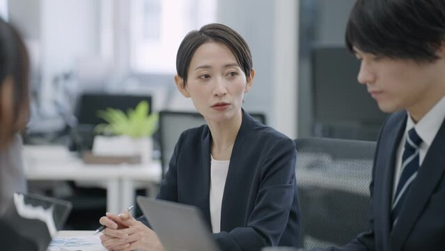 オフィスで会議をするビジネスマンたち（ビジネス・仕事・スーツ・ミーティング）